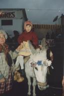 Criança com traje saloio montada num burro.