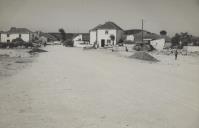 Trabalhadores na construção do Largo de Negrais com <span class="hilite">vista</span> para casas saloias e um poço com nora.