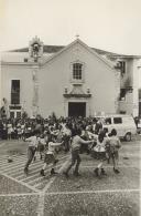 Fachada principal da capela do hospital da Misericórdia de Sintra com atuação de um rancho folclórico infantil no largo Dr. Gregório de Almeida.